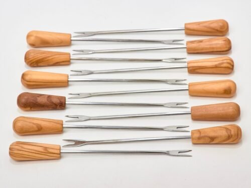 Douze piques à deux dents en acier inoxydable avec manches en bois d’olivier, disposés à plat.